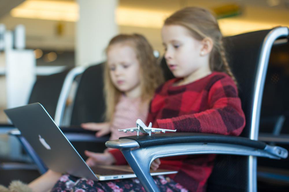 Kids-with-a-laptop-at-the-airport-while-waiting-his-flight_png_85