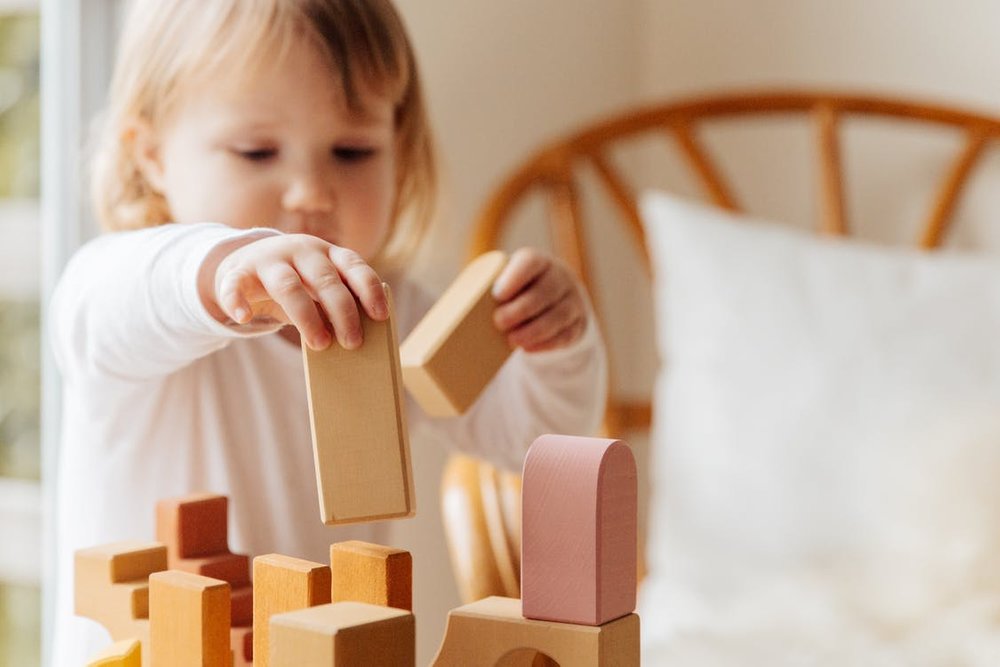 Little-girl-playing-with-wooden-blocks-at-home_png_85
